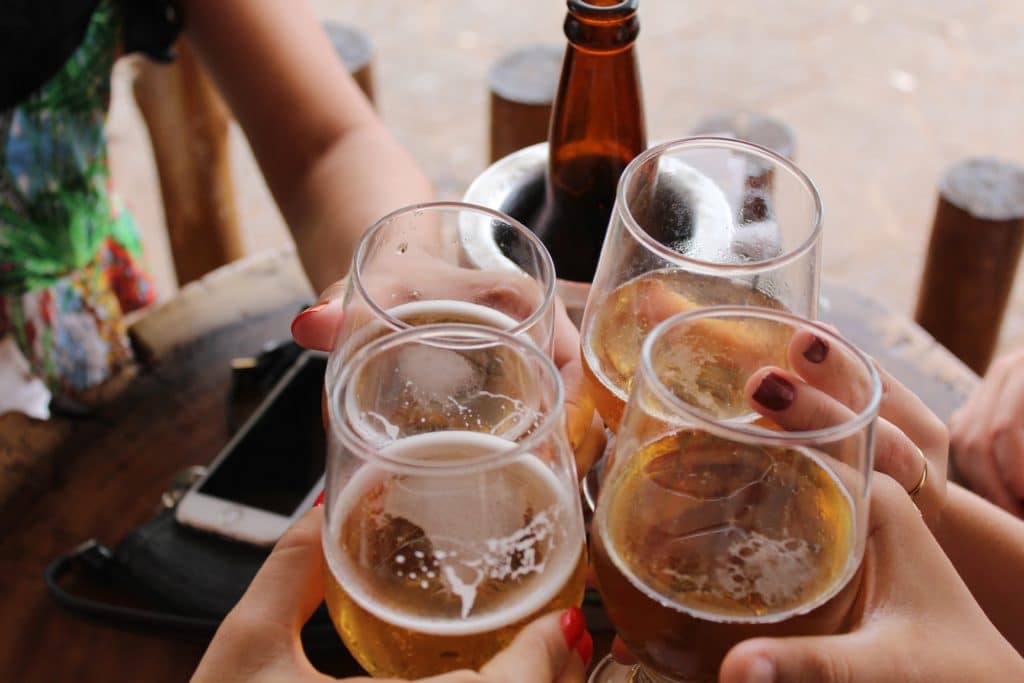 Photo de personnes trinquant dans un bar avec des bières et du vin pour illustrer les bars de Montréal